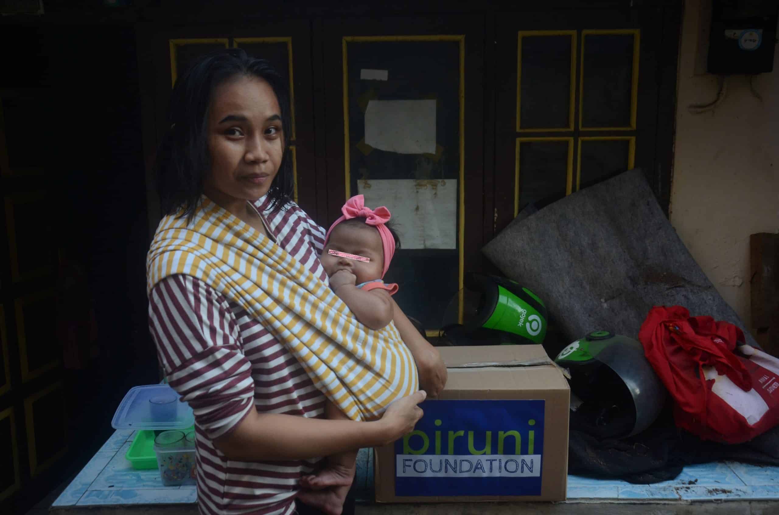 Seorang Ibu, bagian dari aktivitas Biruni Foundation, merawat anak di rumah dengan penuh perhatian